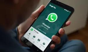 Osoba trzyma smartfon z ekranem Google Play, pokazującym jak ściągnąć WhatsApp na telefon.