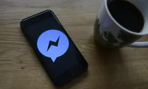 Telefon z ikoną Messengera na ekranie. Dowiedz się, jak ustawić dźwięk powiadomienia Messenger, by nie przegapić ważnych wiadomości.