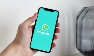 Dłoń trzyma smartfon z włączoną aplikacją WhatsApp. Widzisz, jak działa WhatsApp w telefonie, dzięki czemu możesz łatwo rozmawiać z bliskimi.