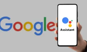 Dłoń trzyma smartfon z logo Asystenta Google. Dowiedz się, jak wyłączyć funkcje AI w Google.