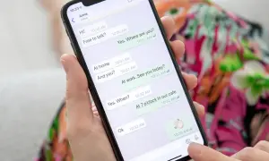 Dłoń trzyma smartfon z otwartym WhatsAppem, pokazującym rozmowę. To może być pomocne, gdy uczysz się, jak założyć WhatsApp krok po kroku.