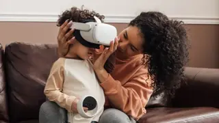 Matka pomaga dziecku założyć gogle VR, zastanawiając się, czy okulary VR są szkodliwe dla dzieci.