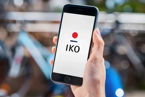 Dłoń trzyma smartfon z logo IKO. Dowiedz się, jak założyć IKO w telefonie, by wygodnie płacić.
