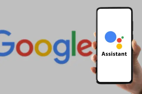 Dłoń trzyma smartfon z logo Asystenta Google. Dowiedz się, jak wyłączyć funkcje AI w Google.