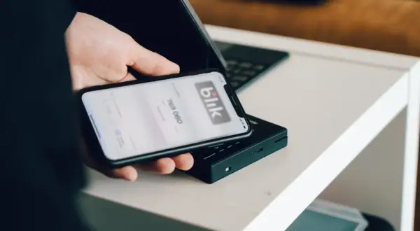 Dłoń trzyma smartfon z aplikacją Blik. Dowiedz się, jak zmienić limit Blik PeoPay.