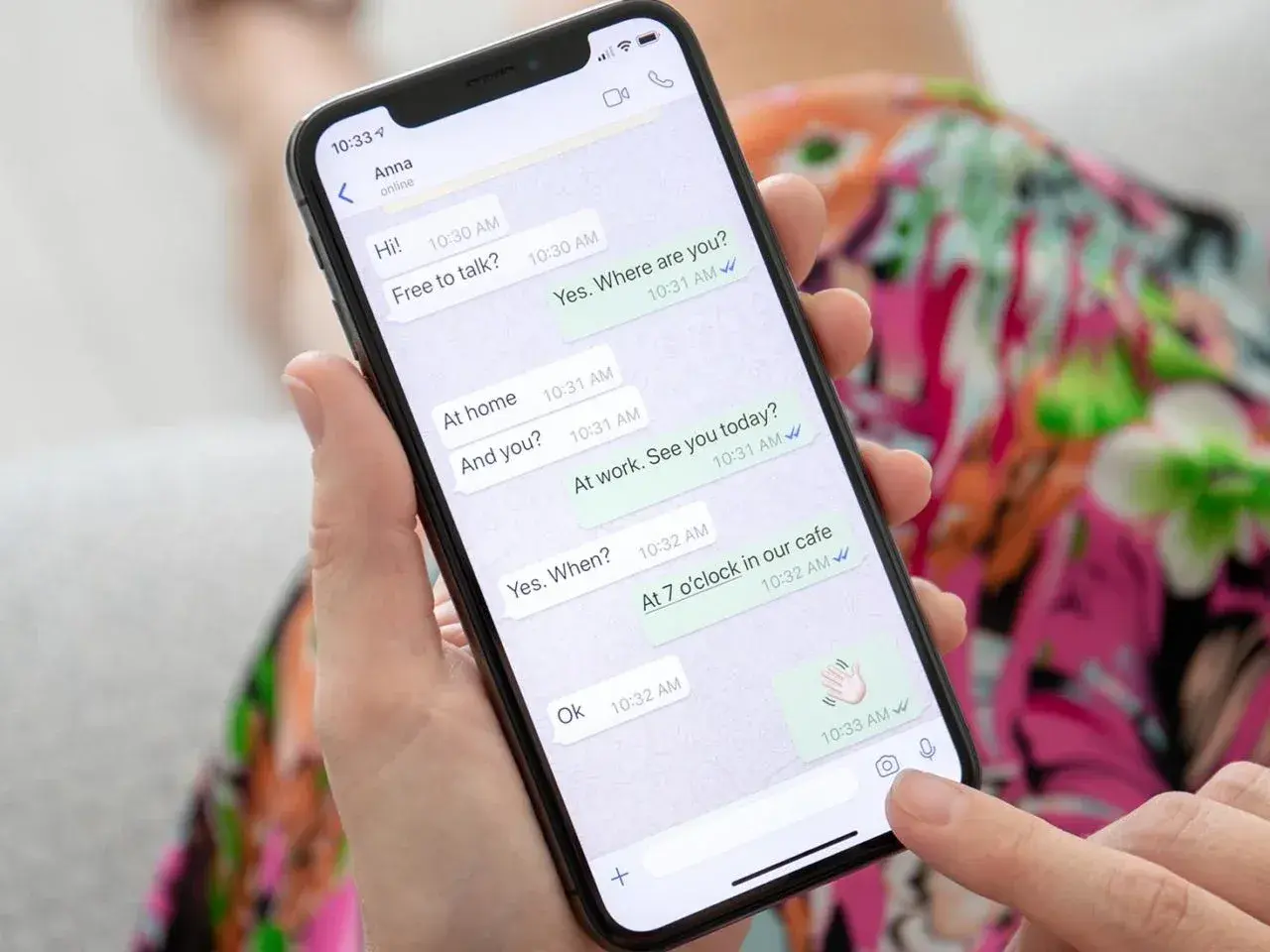 Dłoń trzyma smartfon z otwartym WhatsAppem, pokazującym rozmowę. To może być pomocne, gdy uczysz się, jak założyć WhatsApp krok po kroku.