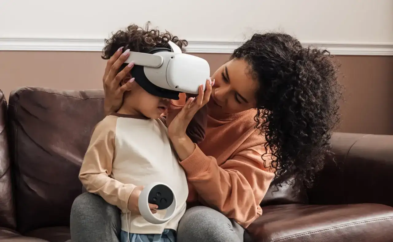 Matka pomaga dziecku założyć gogle VR, zastanawiając się, czy okulary VR są szkodliwe dla dzieci.