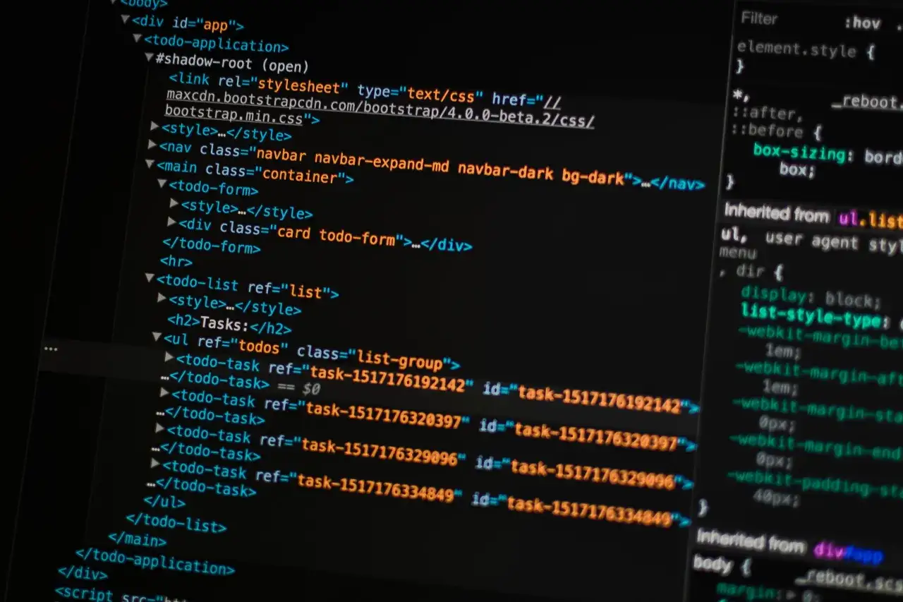 Kod HTML i CSS na ekranie komputera. Pokazuje fragmenty kodu, które można wykorzystać, by nauczyć się, jak zrobić stronę internetową w notatniku.