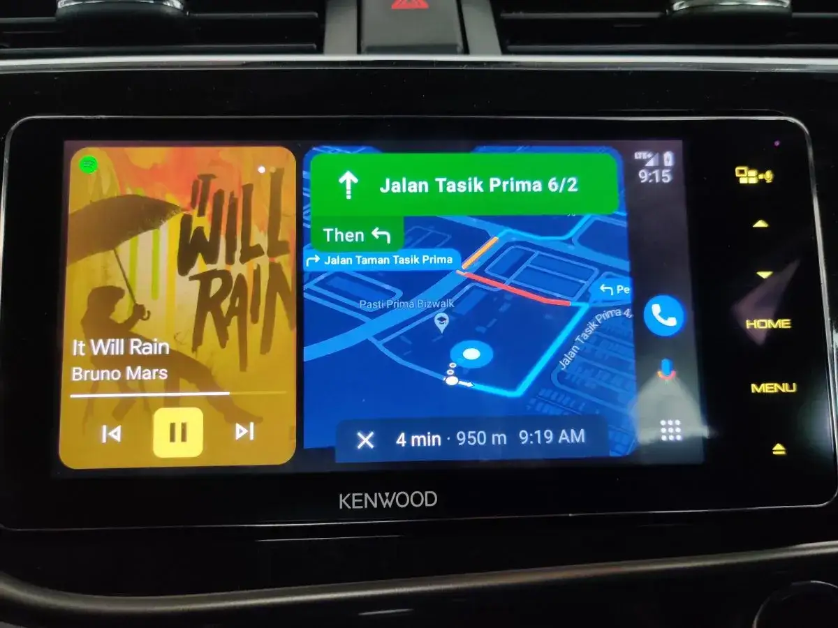 Ekran samochodu z android auto aplikacje: nawigacja Google Maps i odtwarzacz muzyki Spotify z utworem 