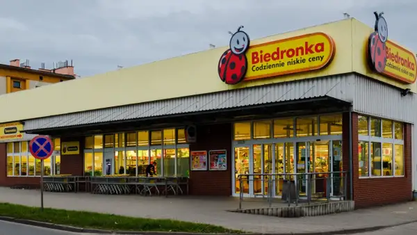 Sklep Biedronka z charakterystycznym logo. Dowiedz się, jak zarejestrować kartę Moja Biedronka, by korzystać z promocji.