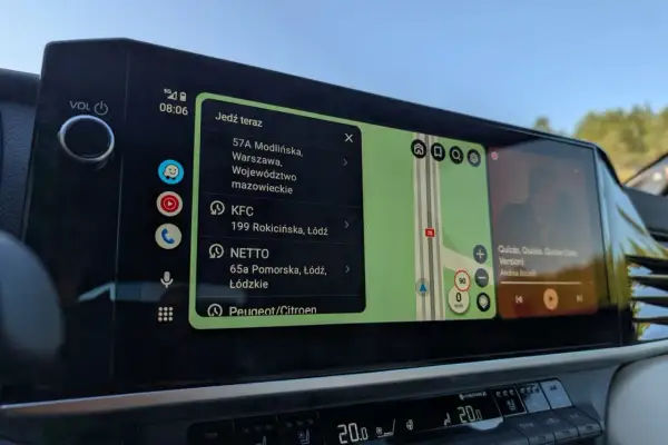 Na ekranie samochodu widać **android auto aplikacje**: nawigację z trasą, listę miejsc (KFC, NETTO) i odtwarzacz muzyki.